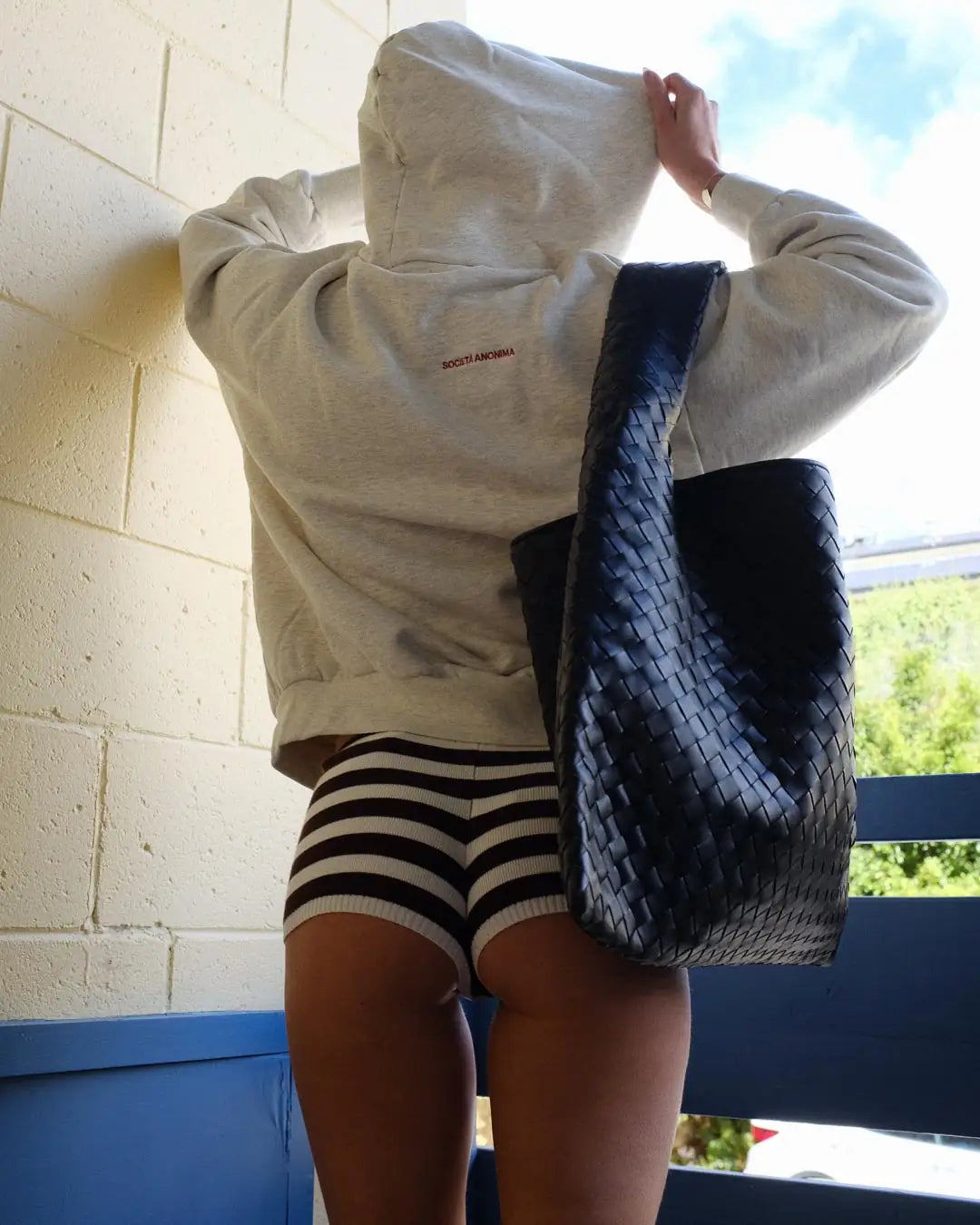 Woman wearing Societa Anonima hoodie in marle grey
