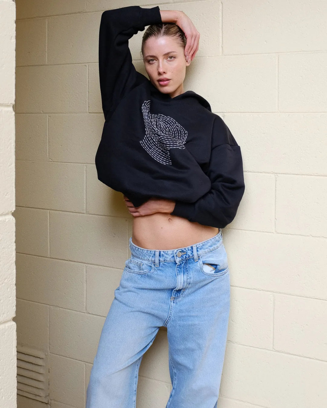 Woman wearing Societa Anonima hoodie in black with fingerprint embroidery on the front
