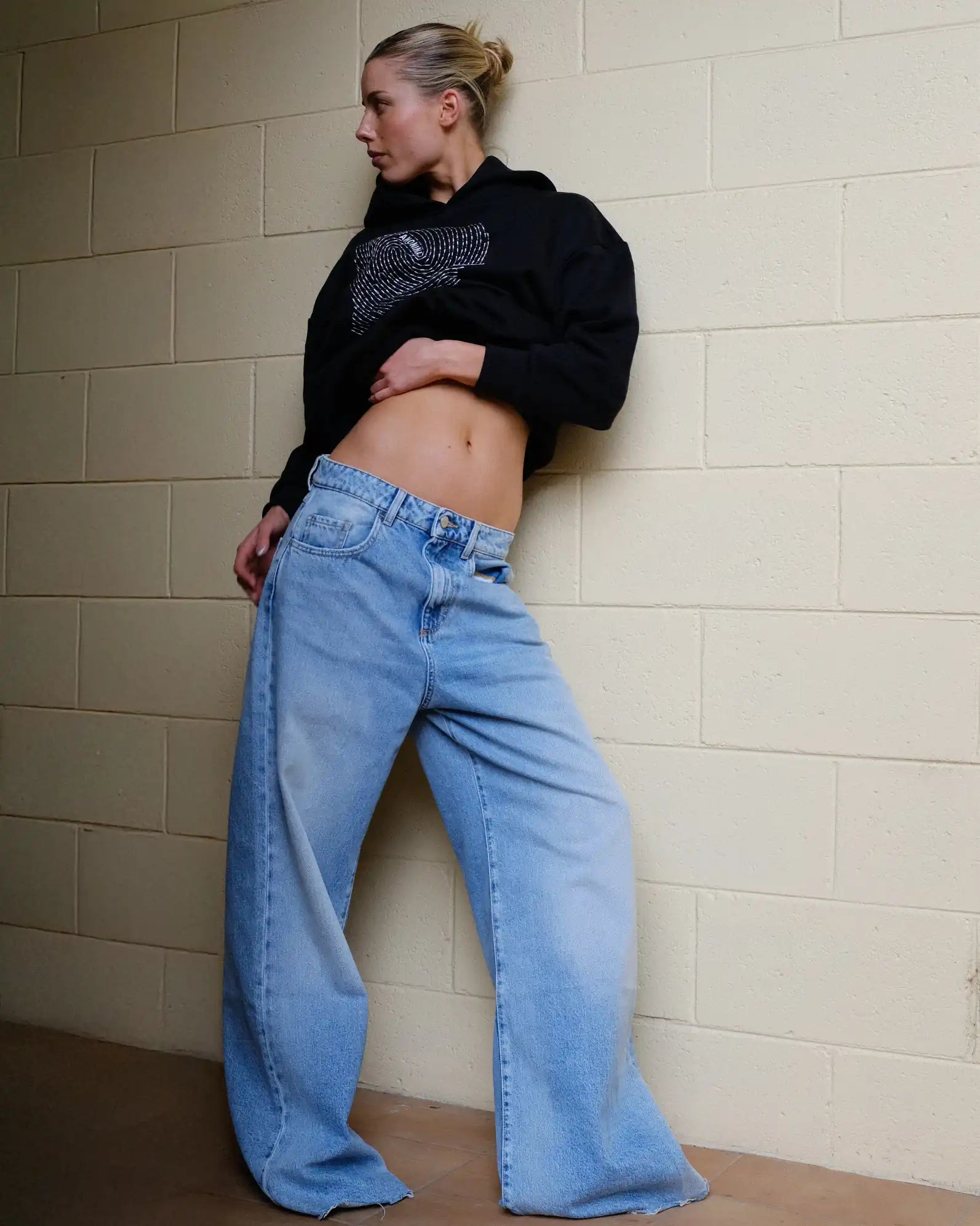 Woman wearing Societa Anonima hoodie in black with fingerprint embroidery on the front