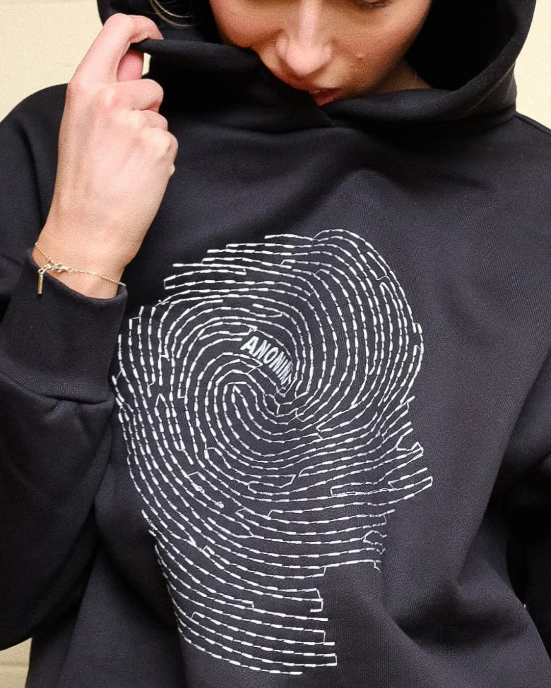 Woman wearing Societa Anonima hoodie in black with fingerprint embroidery on the front