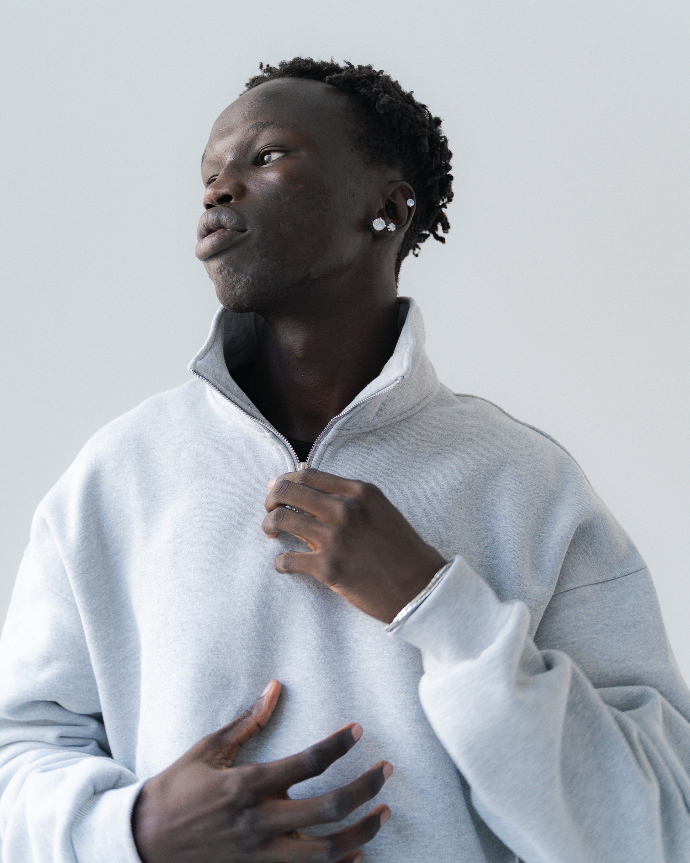 Man wearing a light gray sweater against a plain background